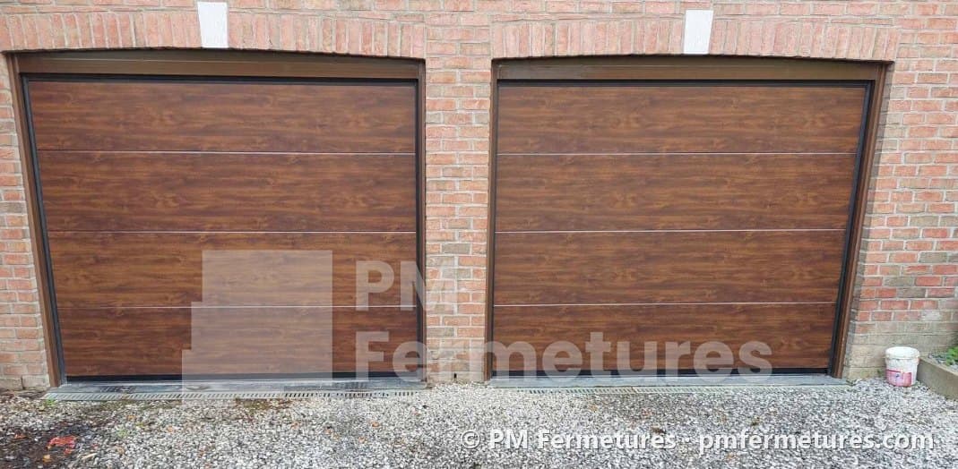 Deux portes de garage sectionnelles en imitation chêne sur une façade en briques